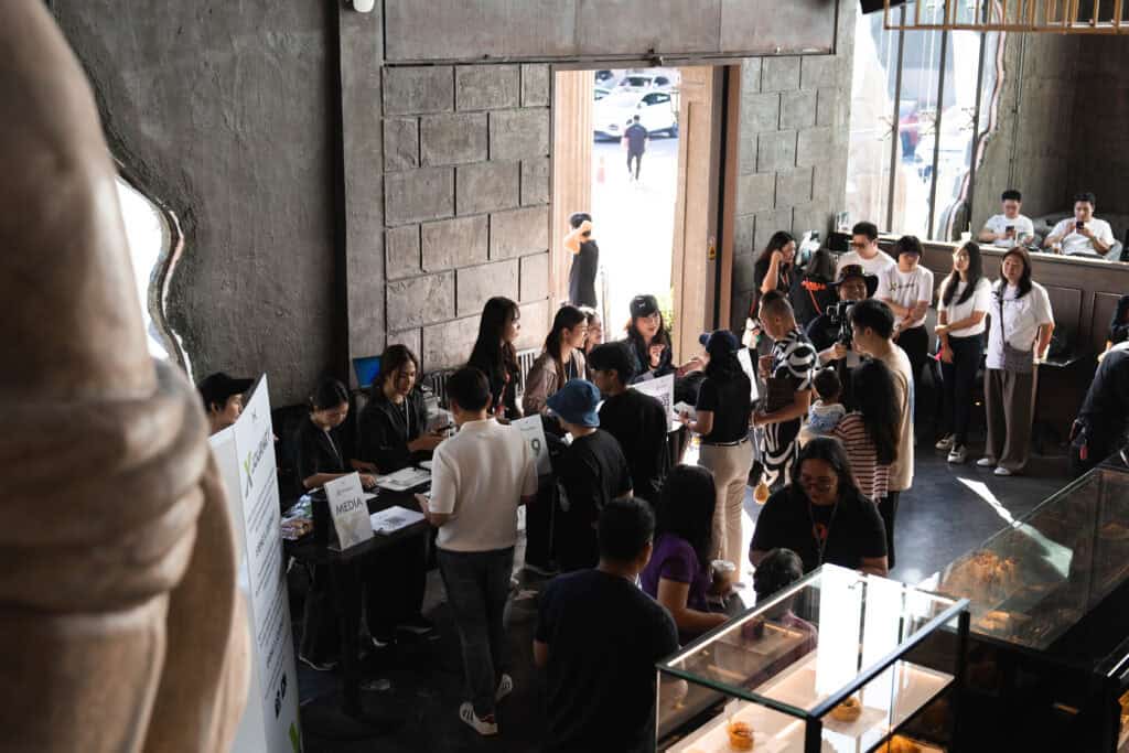 A seminar registration and check-in area at Davin Cafe in Bangkok, where attendees queue to receive event materials, demonstrating organized event flow and professional venue management
