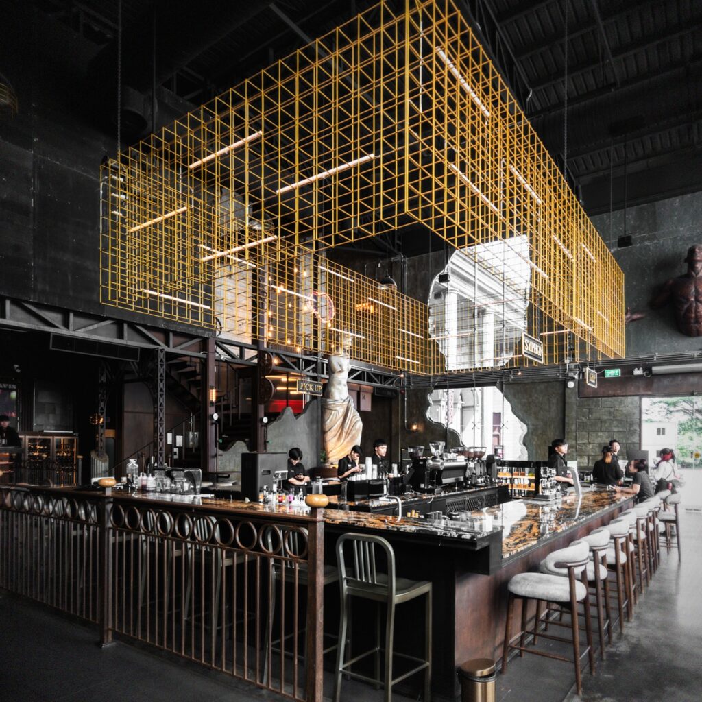 มุมบาร์ขนาดใหญ่ภายใน Davin Cafe ร้านคาเฟ่สไตล์ ยุโรปในกรุงเทพ ที่ผสมผสานเคาน์เตอร์หินอ่อน โครงสร้างเหล็กสูง และงานตกแต่งคลาสสิก ให้บรรยากาศหรูโดดเด่นเหมาะสำหรับนั่งจิบกาแฟ ถ่ายรูป และสัมผัสประสบการณ์คาเฟ่ที่แตกต่างจากร้านทั่วไป