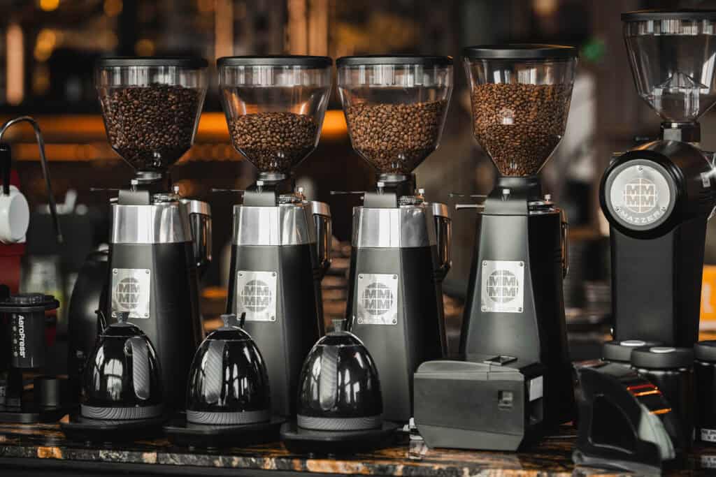 Coffee grinders and roasted bean hoppers at Davin Cafe, representing the Flavor Exchange experience through specialty coffee selection, grind preparation, aroma comparison, and a deeper exploration of tasting profiles.
