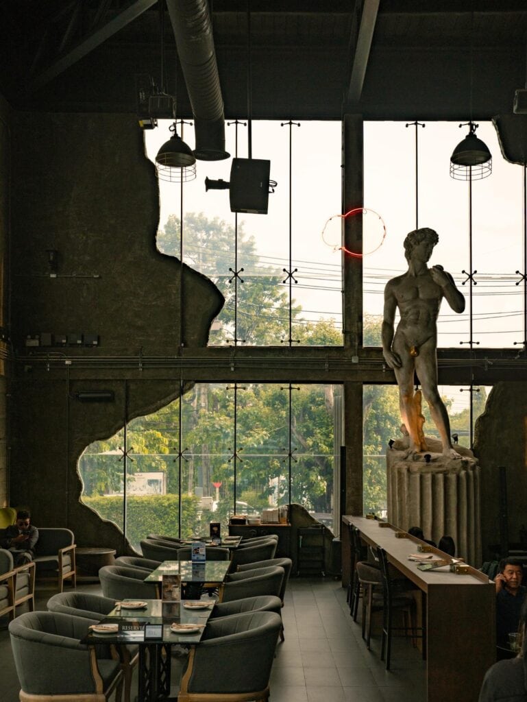 คาเฟ่อ่านหนังสือ DAVIN CAFE ย่านเลียบด่วน กับมุมนั่งภายในโปร่งสบาย กระจกบานใหญ่ แสงธรรมชาติ และประติมากรรมสไตล์คลาสสิก
