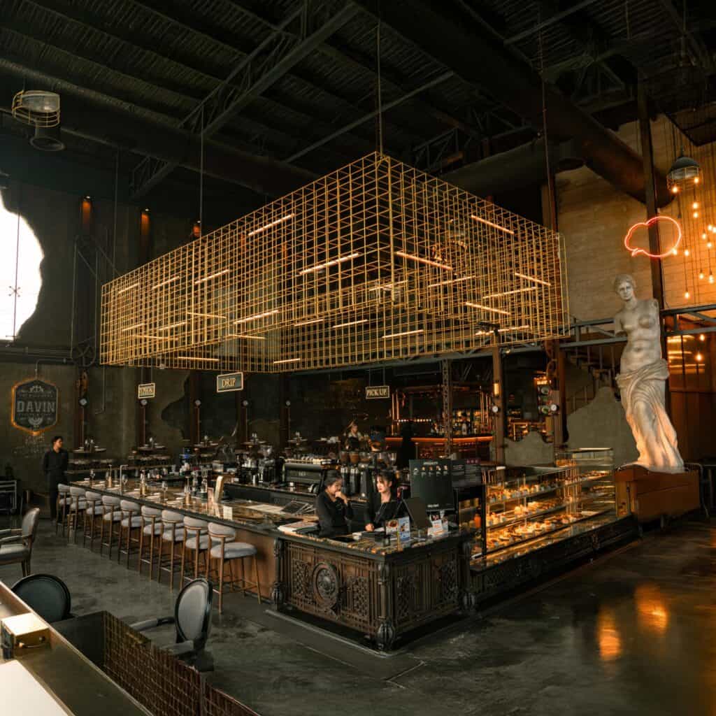 Spacious reading cafe interior at DAVIN CAFE Bangkok with industrial design, Specialty Coffee counter, and multiple seating areas